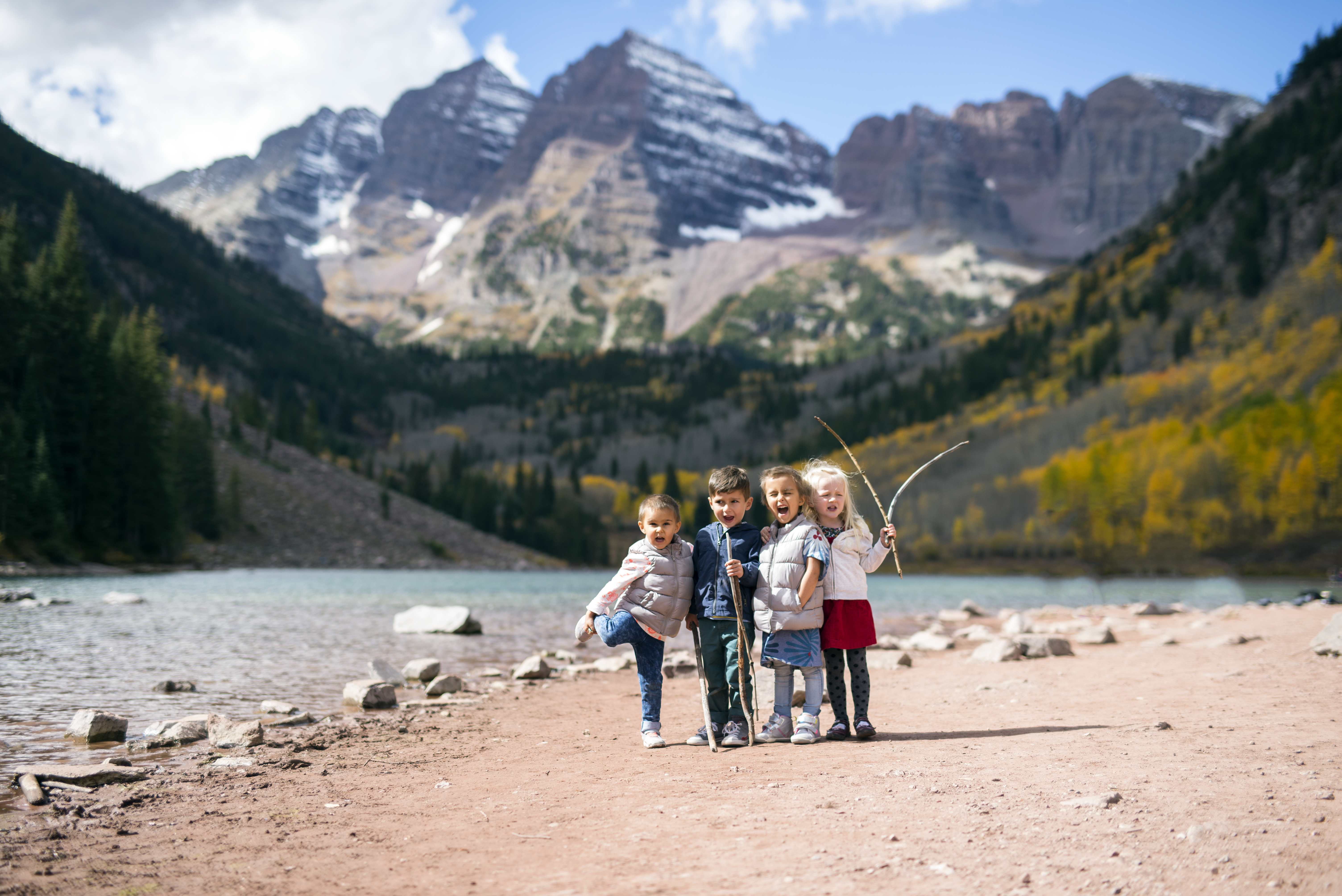 Children enjoying the scenic view of Maroon Bells during a Colorado road trip in autumn.
