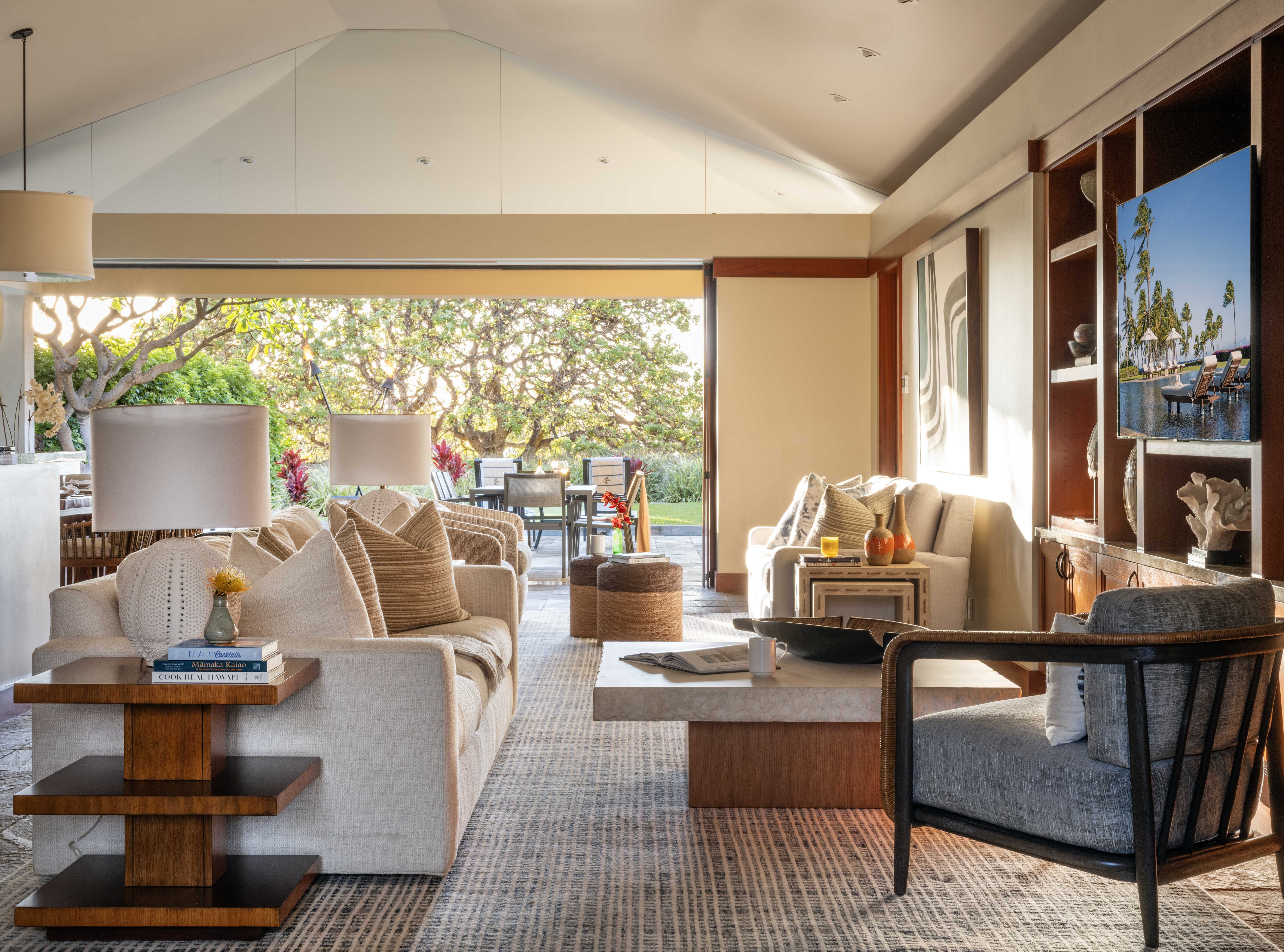 Luxurious living room with open-air dining area and garden view on the Kohala Coast at Pauoa Beach Club.