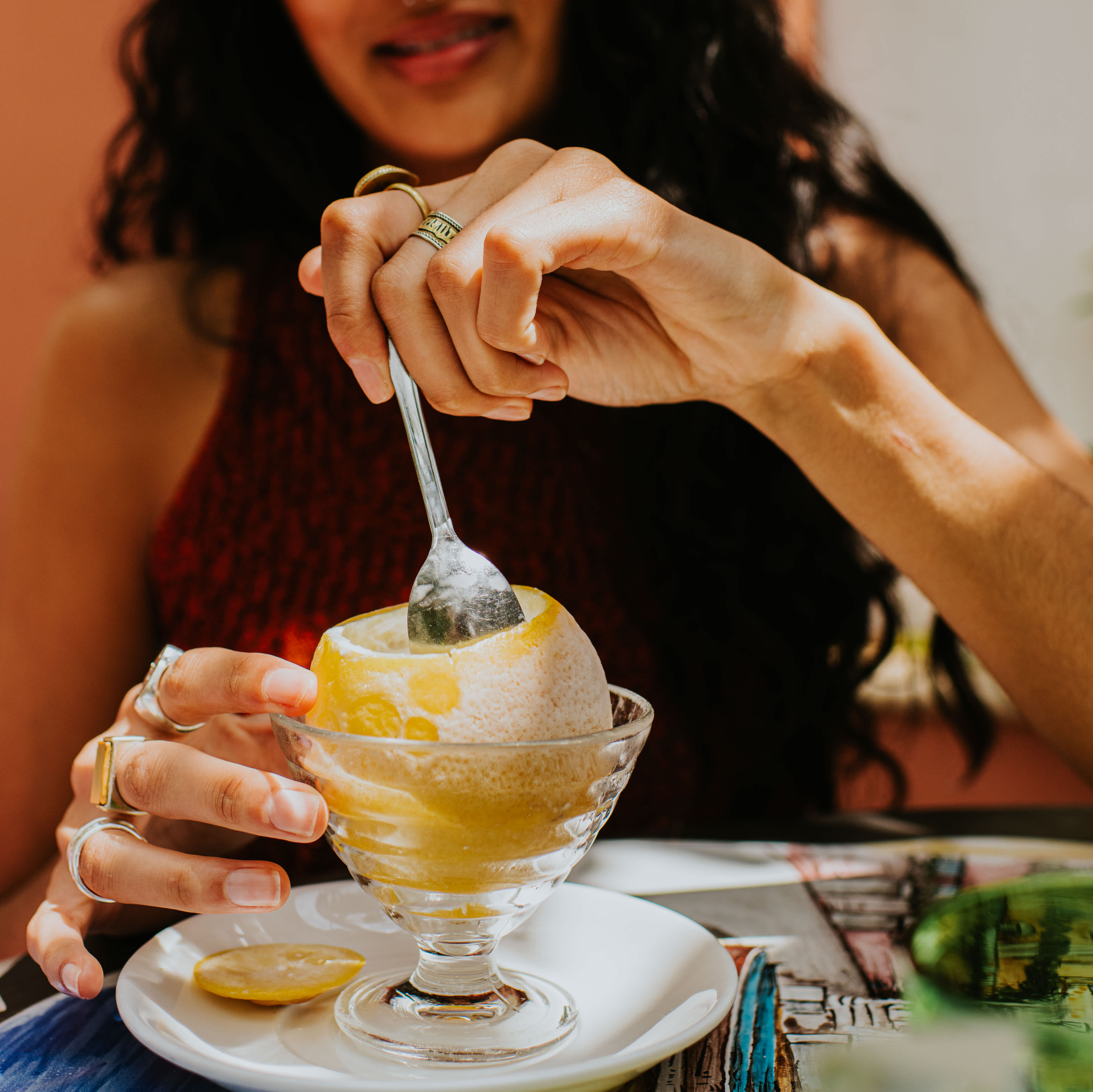 Woman enjoying a lemon sorbet in a glass dish on the Amalfi Coast.