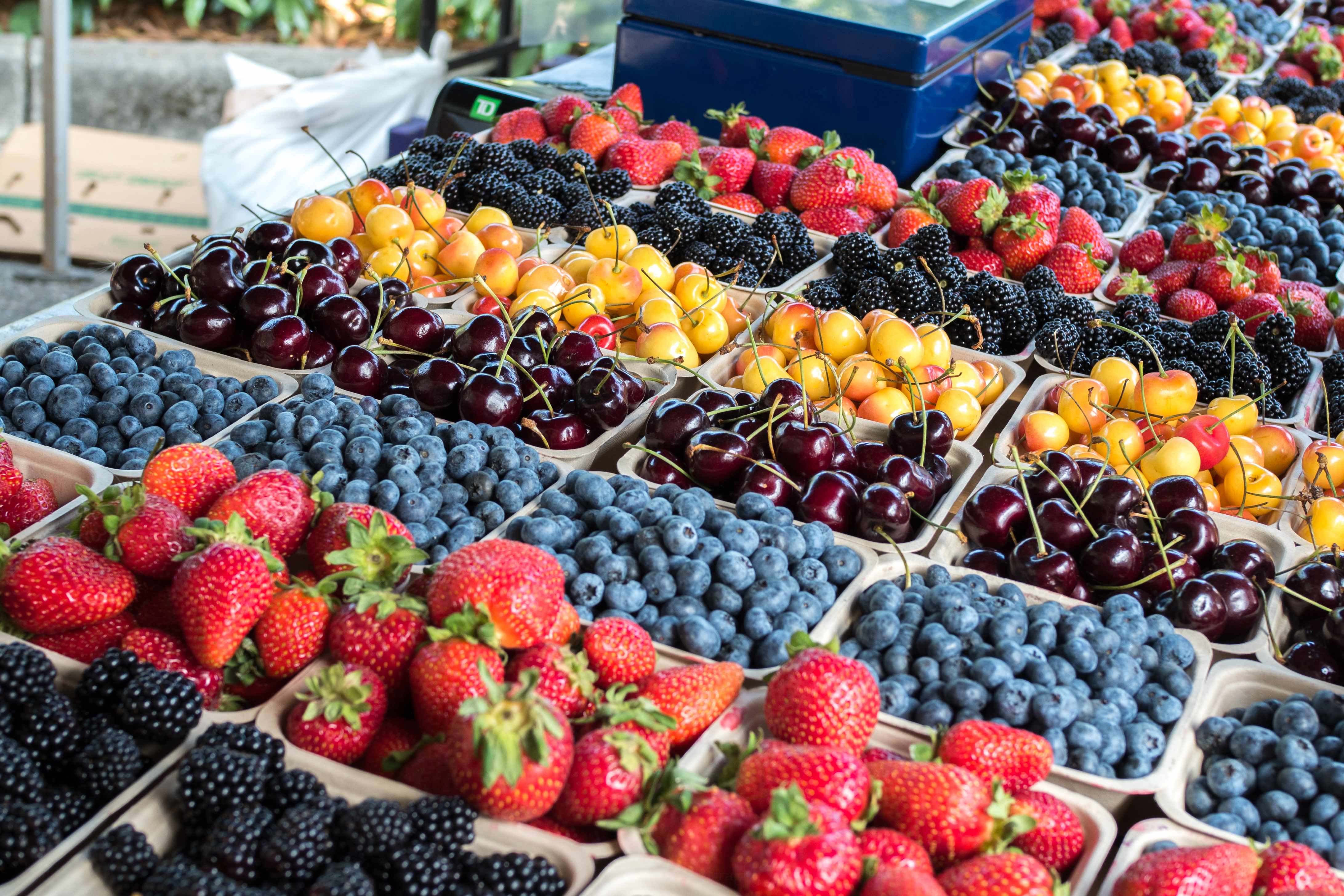 An assortment of fresh berries, including strawberries, blackberries, blueberries, and cherries.