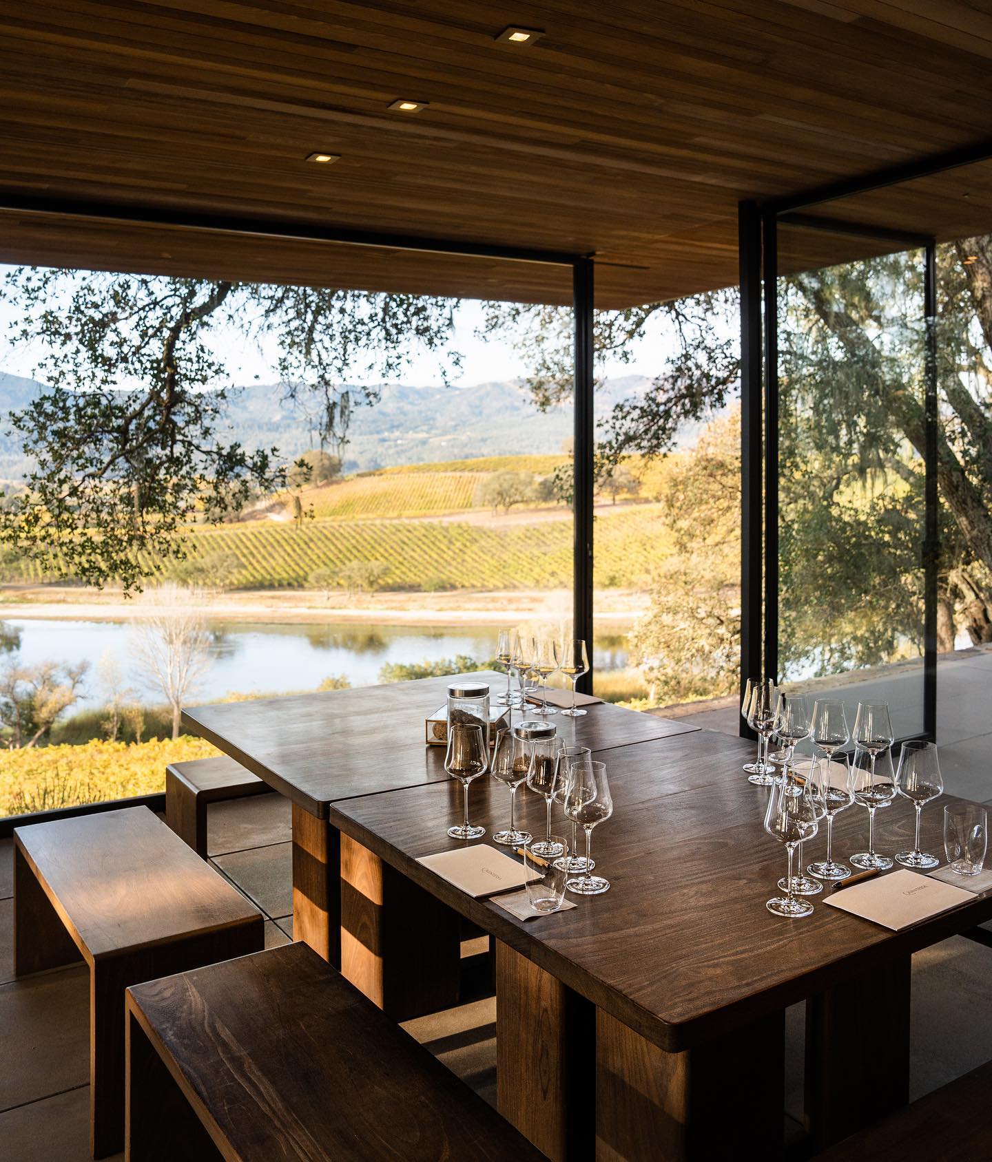 Wine tasting room at Quintessa with large windows offering a view of the vineyard and lake.