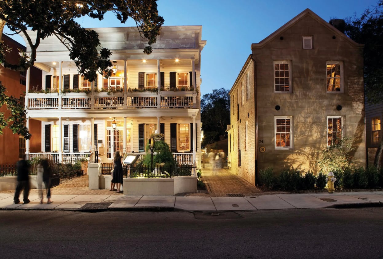 Husk restaurant in Charleston at dusk with warm lighting and people outside.