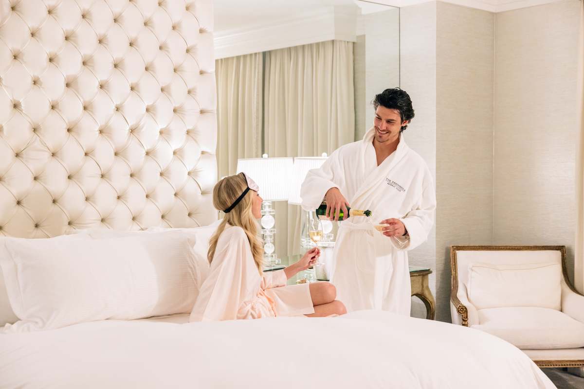 Couple enjoying champagne in a luxurious room at The Peninsula Beverly Hills hotel.
