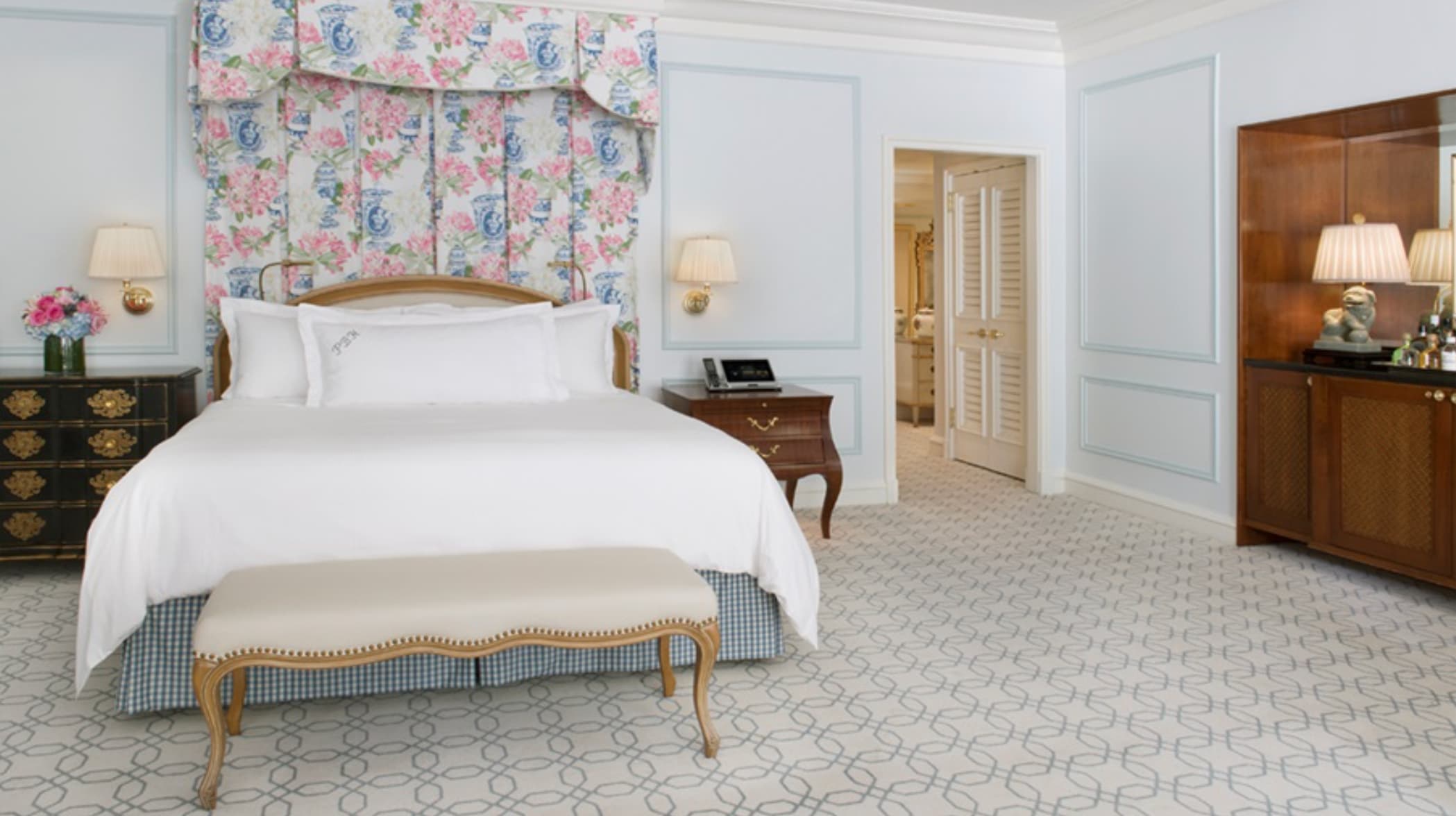 Luxurious bedroom at The Peninsula Beverly Hills with floral decor and elegant furnishings.