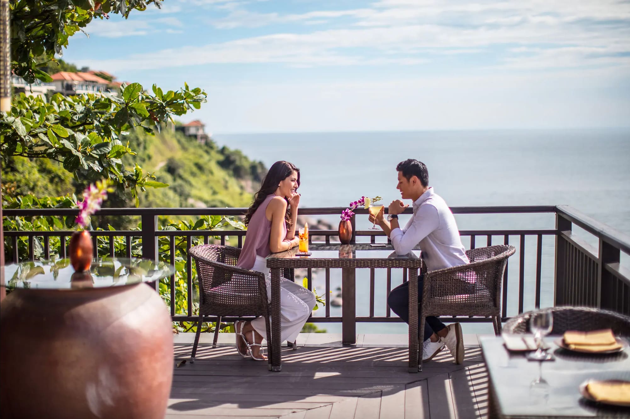 Couple enjoying a romantic meal on a terrace with ocean views at Banyan Tree Lang Co, Vietnam.