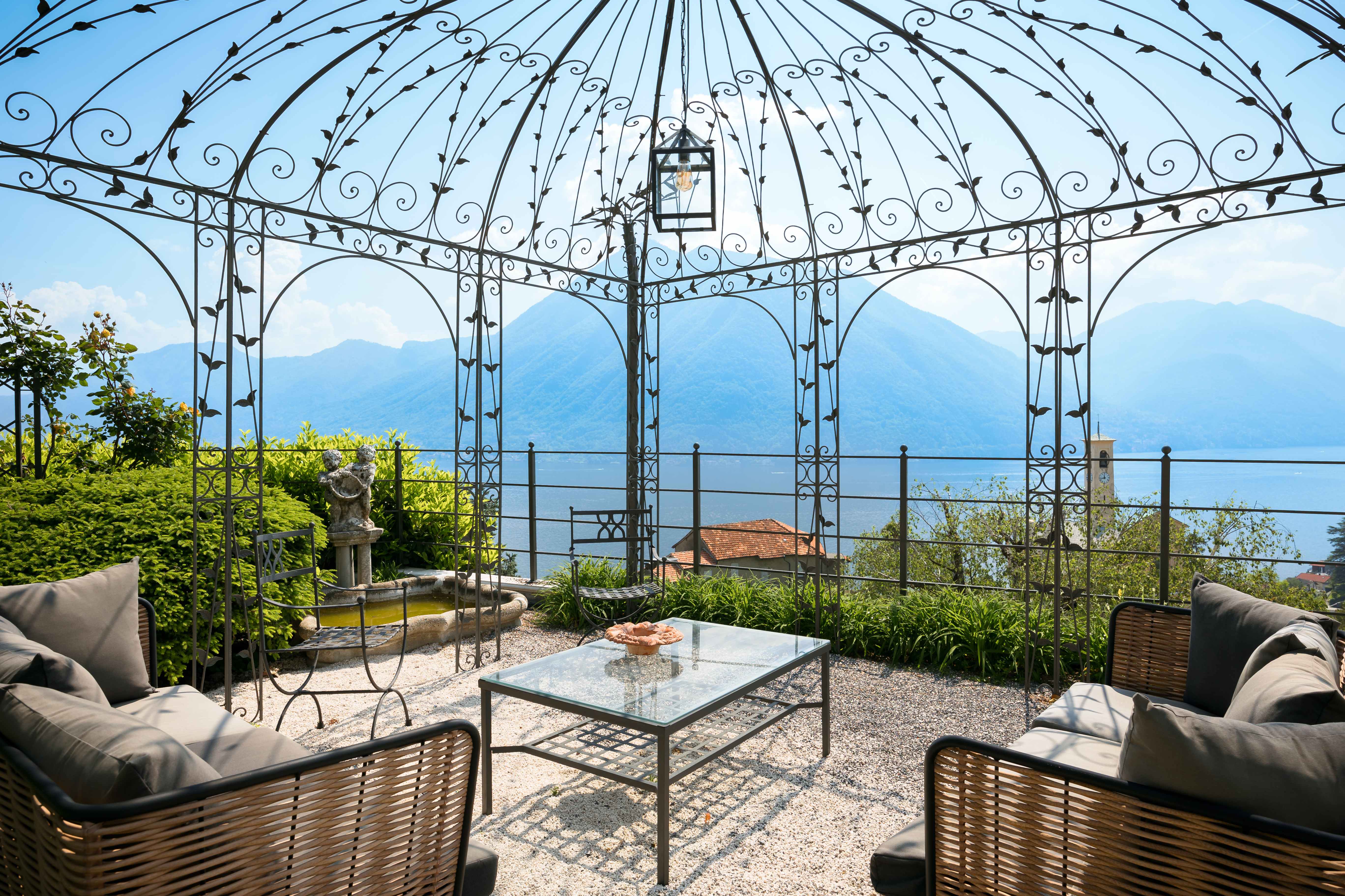 Exclusive Resorts' villa with a view of Lake Como, framed by elegant wrought iron gazebo.