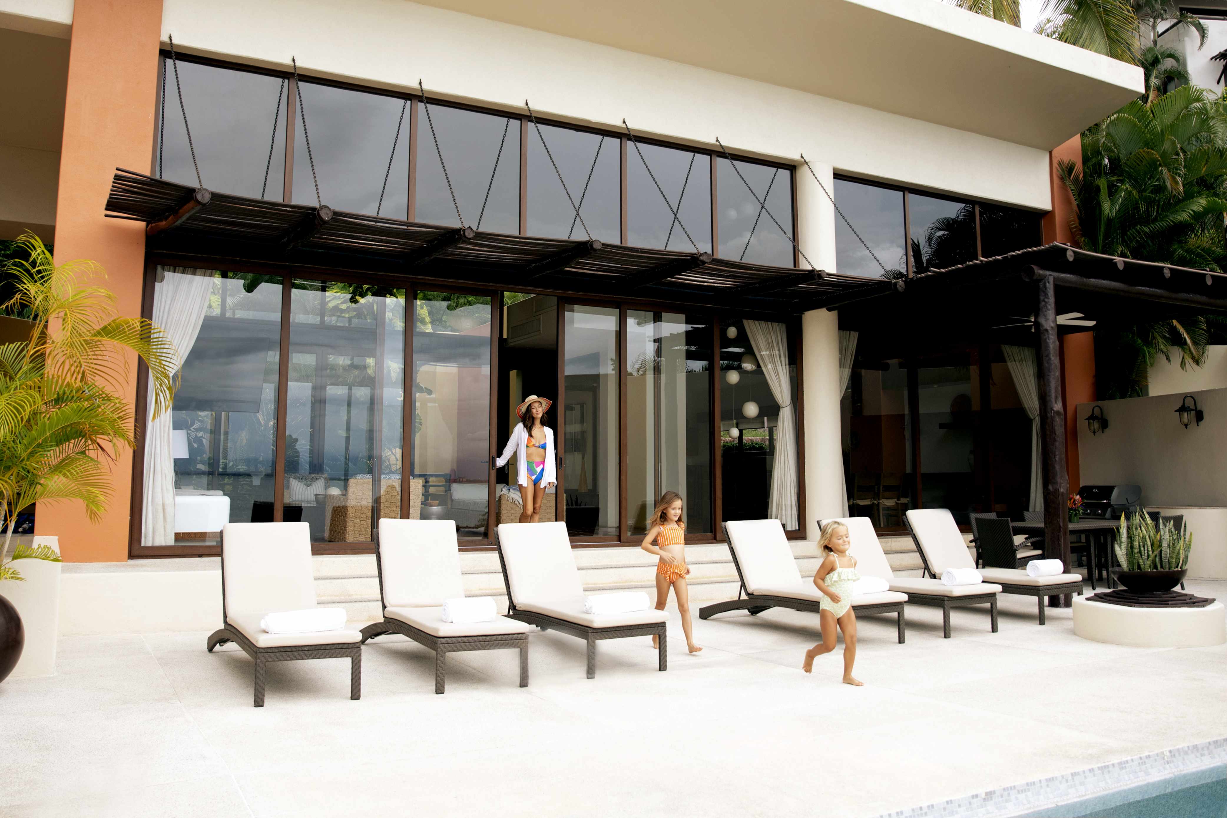 Mother following her daughters out to pool of a private home in Real del Mar, Mexico.